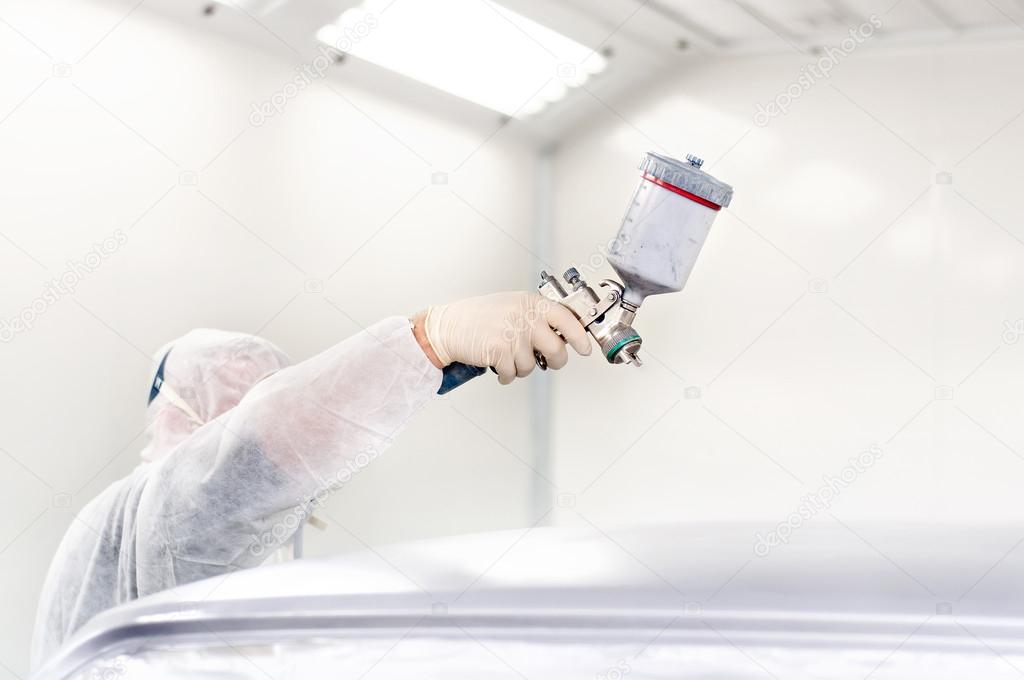 Worker using a paint spray gun for painting a car in a special booth Stock  Photo by ©bogdan.hoda 32177617